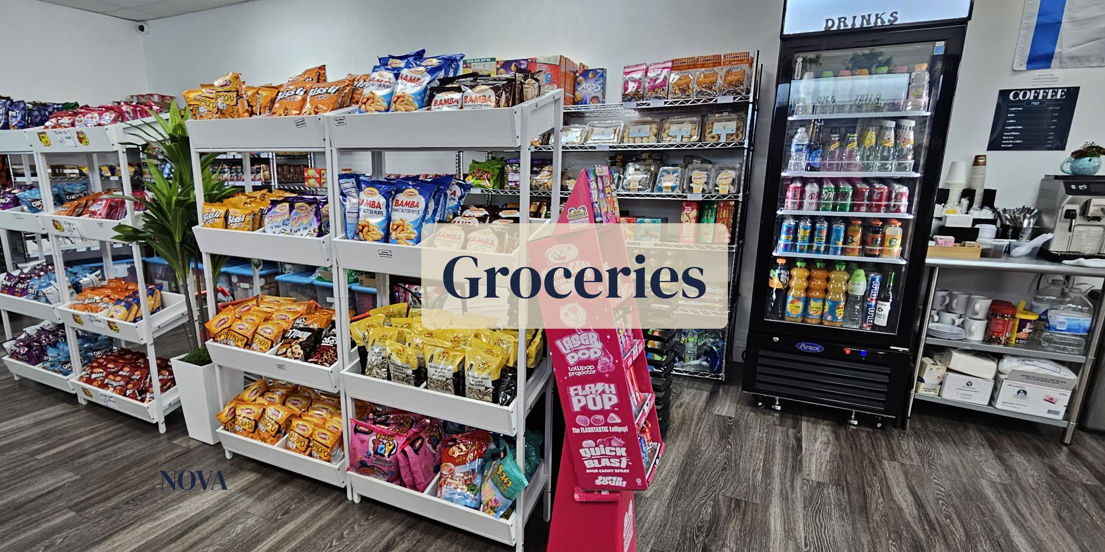 Grocery store interior with shelves stocked with products and a sign indicating 'Groceries'.